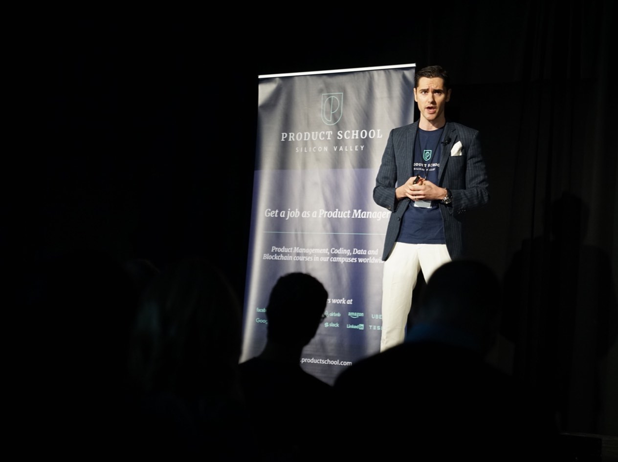 Man standing on stage giving a presentation